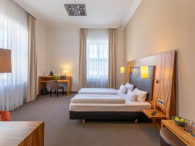 Komfortables Bett im Superior-Doppelzimmer mit Domblick