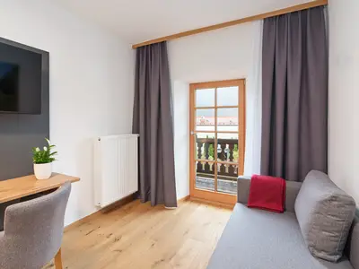 Einzelzimmer mit Schlafcouch und Balkon
