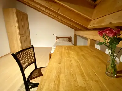 Schreibtisch mit Einzelbett im Hintergrund