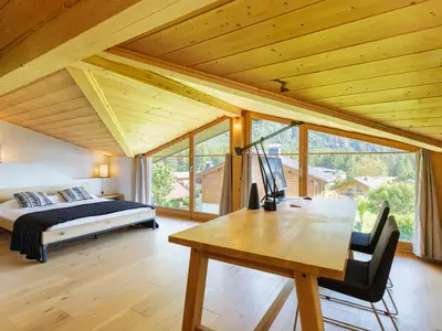 Schlafzimmer mit Doppelbett, Laptop-Arbeitsplatz und Bildschirm