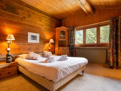 Schlafzimmer 2 mit einem Doppelbett und Blick auf den Wald