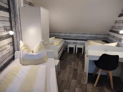 Schlafzimmer mit drei Einzelbetten und Klimaanlage