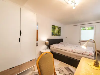 Schlafzimmer mit Schreibtisch und Schrank