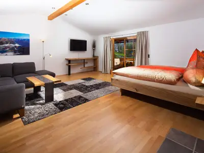 Wohnzimmer mit Couch und Doppelbett Fewo Sonnenschein