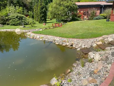 Außenansicht des Gebäudes. Ferienhaus und Gartenteich