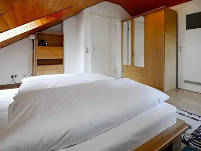 Schlafzimmer mit Doppelbett und Kleiderschrank