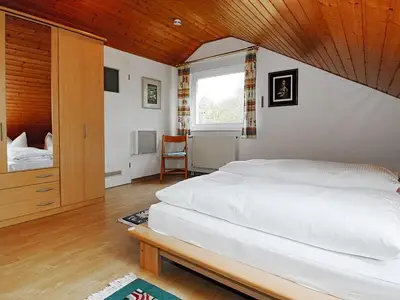 Schlafzimmer mit Doppelbett und Kleiderschrank