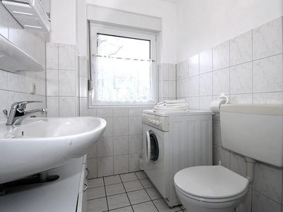 Badezimmer mit Waschmaschine und WC