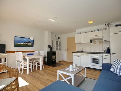 Wohnzimmer mit Sofaecke, Essbereich, Küche, Kamin und TV