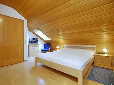 zweites Schlafzimmer mit Doppelbett und TV
