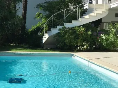 Aussentreppe zum oberen Stockwerk mit 3 Schlafzimmern und Wohnzimmer & Pool mit Palmen & vielen Pflanzen