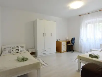 Schlafzimmer 2 im ersten Stock mit zwei Einzelbetten, Kleiderschrank und Schreibtisch.