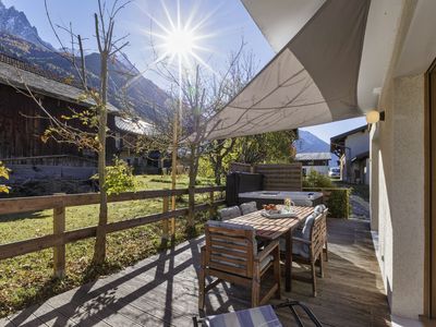 Teilweise überdachte, geräumige und angenehme Terrasse mit Essmöbeln