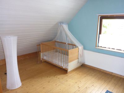 Großes Schlafzimmer oben mit Kinderbett