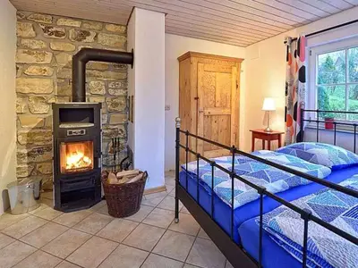 Schlafzimmer mit Doppelbett und Kamin