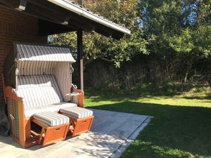 Terrasse. Ein Strandkorb lädt zum windgeschützten Sonnenbaden ein.