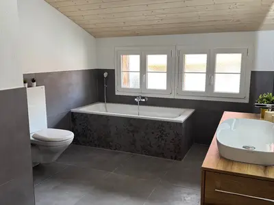 Badezimmer mit Badewanne und Regendusche
