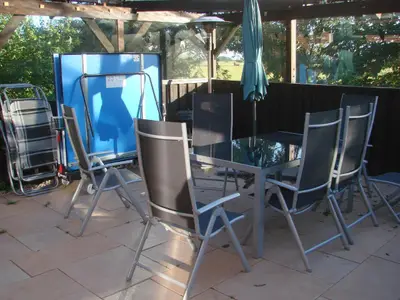Zurück zum Pavillon: mit Gartenmöbeln. Hier kann man auch bei starkem Wind gemütlich sitzen und auch TT spielen.