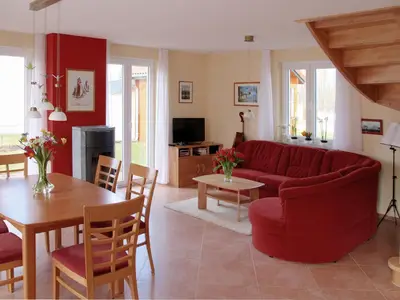 Wohnzimmer mit Esstisch, Kamin, E-Piano und Terrassentüren nach Süden und Westen
