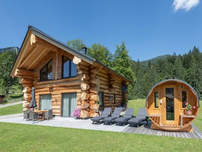 Ansicht vom Zedernblockhaus im Sommer mit Sauna