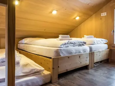 offenes Zimmer mit zwei Einzelbetten und ein weiteres offenes Zimmer mit einem Einzelbett. Zusätzlich gibt es bei beiden