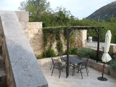 Schöne Terrasse mit Möbeln, Sonnenschirm und Pergola