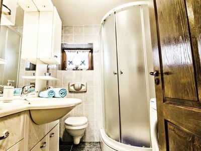 Das Badezimmer mit Dusche, WC, Waschbecken mit Schrank und Spiegel im Erdgeschoss