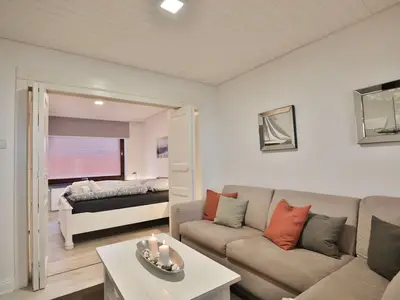 Nautic Lounge 45 – Wohnbereich mit gemütlichem Sofa und direktem Zugang zum Schlafzimmer in Scharbeutz-Haffkrug.