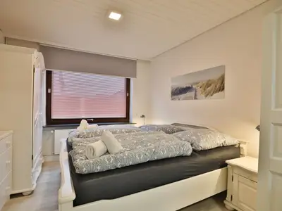 Nautic Lounge 45 – Modernes Schlafzimmer mit Doppelbett und maritimer Dekoration in Scharbeutz-Haffkrug.