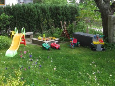 Gemeinschaftsgarten mit Sandkasten und Spielsachen