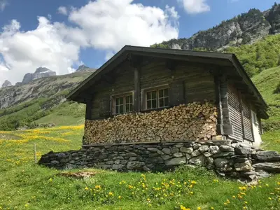 Alphütte Gental, mit Holz für ein schönes Feuer im Ofen in der Stube