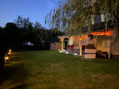 Der Garten in der Abenddämmerung mit blick auf die Terrasse