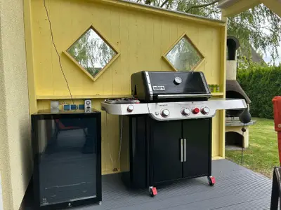 Auf der Terrasse steht ein outdoor Kühlschrank und ein Webergrill Genesis E-335 zur Nutzung bereit