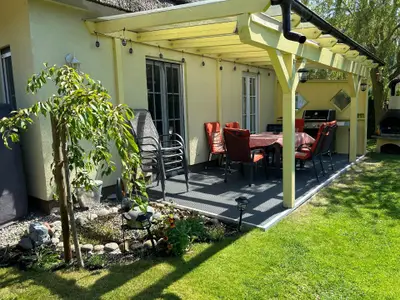 Blick auf die Terrasse mit Webergrill und Kühlschrank