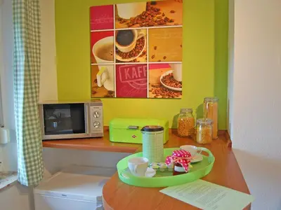 Küchentresen mit der Mikrowelle und dem zweitem Kühlschrank mit Gefrierfach.