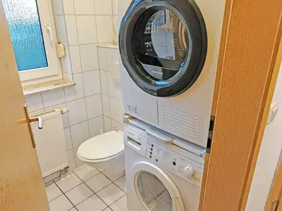 Gästetoilette mit Waschmaschine und Wäschetrockner.