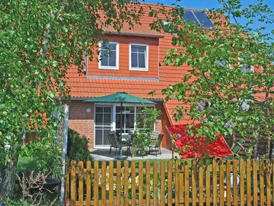 Komplett umzäunter grün gewachsener Garten mit Terrasse.