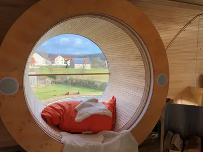 Das Bullauge als besonderer Chillingplace im UFO47 mit Blick auf den Schwimmteich