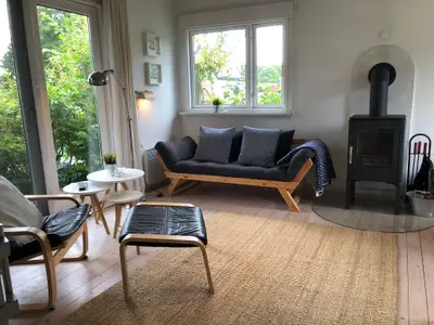 Wohnzimmer mit Couch, TV, Ofen, Essbereich