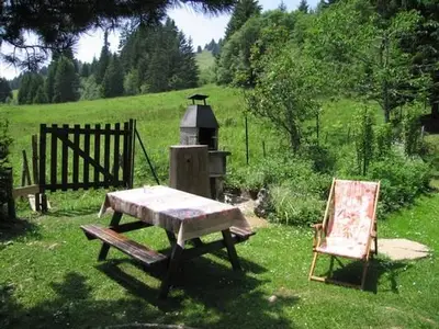 Gartengrill und Sicht auf die Almweide im Garten des Chalet