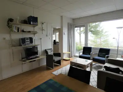 Wohnbereich. Modernes, geräumiges, möbliertes Zimmer mit Blick über das Tal und das Dorf