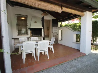 Die überdachte Terrasse mit Grill und Gartenmöbel