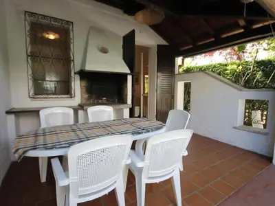 Die überdachte Terrasse mit Grill und Gartenmöbel