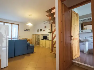 Wohnbereich. Wohnzimmer mit Esstisch und Ausgang zur Veranda mit Grill