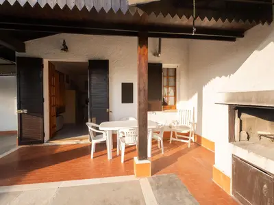 Terrasse. Ueberdachte Terrasse mit Gartenmöbeln und Grill