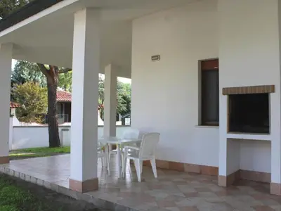 Garten. Ueberdachte Terrasse mit Grill und Gartenmöbeln