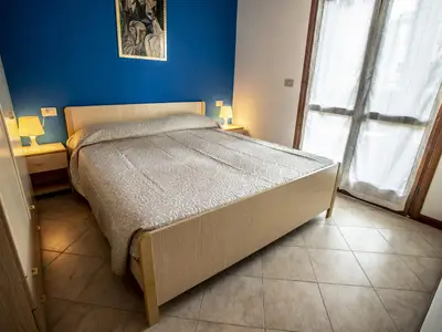 Schlafbereich. Schlafzimmer mit Doppelbett und Ausgang zum kleinen privaten Garten