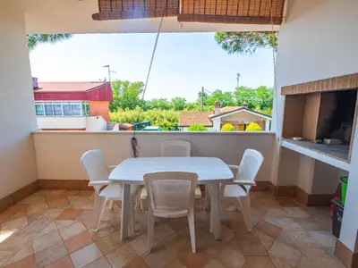 Terrasse. Ueberdachte Terrasse mit Gartenmöbeln und Grill