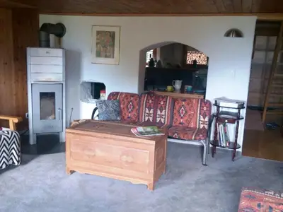 Stube mit 3 Sofagruppen, Lesestuhle und Chemineofen.