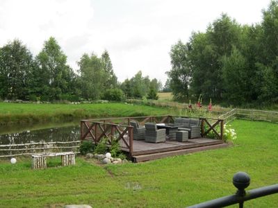 Blick auf die Terasse am Gartenteich mit gemütlicher Sitzecke